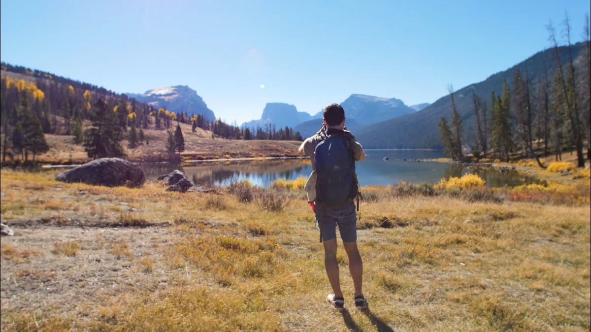 Zach walks across a brige over a roaring river